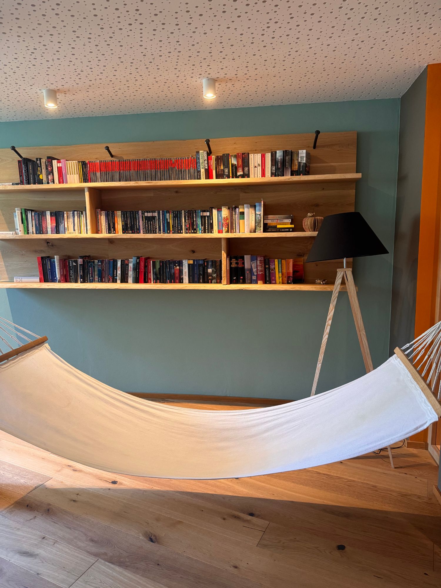 Hotel-Bibliothek mit Holzregalen und Hängematte
